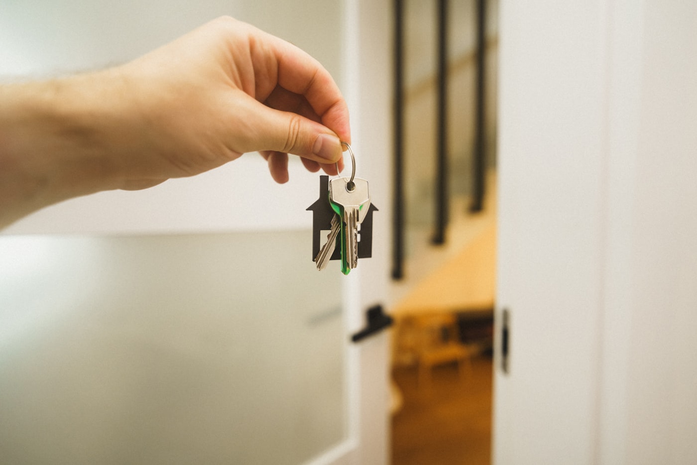 Hand met sleutelbos van een huurwoning in een deuropening