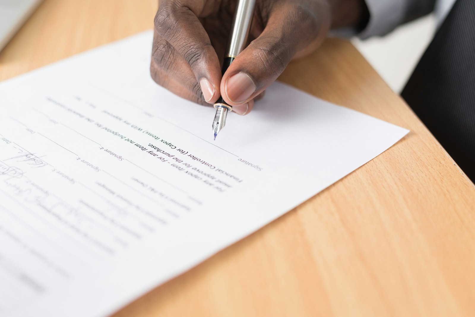 Iemand ondertekent een huurovereenkomst met een pen aan een bureau