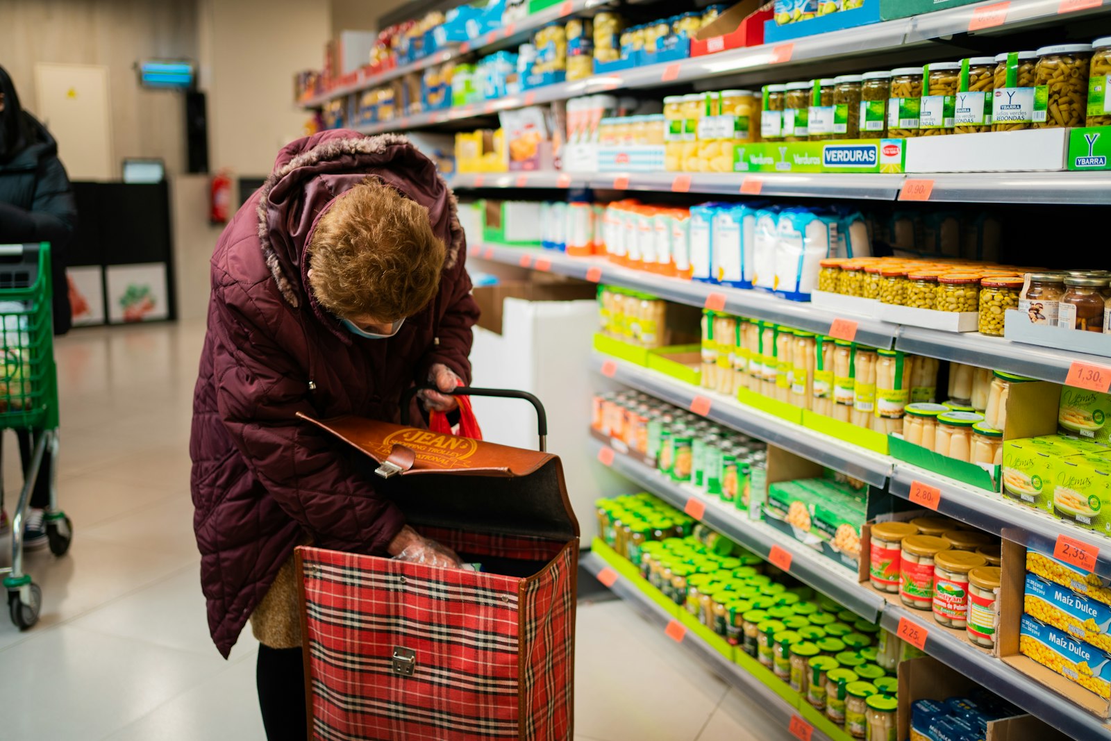 Jonge medewerker achter de kassa van een supermarkt