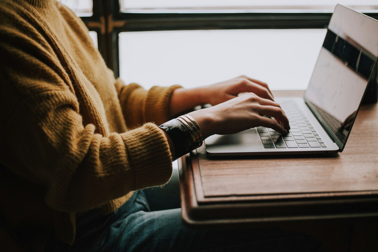 Student werkt op een laptop aan een scriptie in een studentenkamer